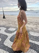 Vestido largo marrón de crepe texturizado, con cuello halter fruncido, diseño holgado y falda larga con vuelo.