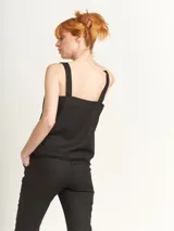 Musculosa verde agua con escote en V, breteles anchos con detalle de argollas de madera y ruedo con flecos.