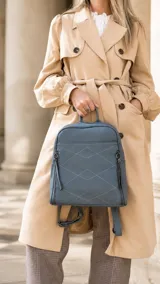 Mochila de diseño estructurado en color bordó, confeccionada en símil cuero con costuras decorativas en forma de rombos en el frente. Cuenta con un bolsillo frontal con cierre, asa superior de mano y correas regulables.