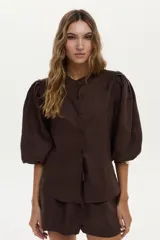 Camisa de lino blanca con mangas abullonadas y diseño para anudar al frente.
