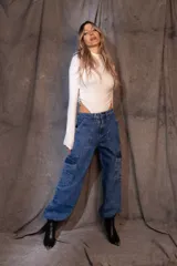 Pantalón cargo de denim azul con calce holgado, tiro medio, bolsillos laterales con solapa y elásticos ajustables en cintura y tobillos.