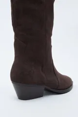 Bota texana de caña alta confeccionada en gamuza negra, con diseño de estilo western, costuras decorativas, tirador superior y taco bajo levemente inclinado.