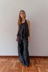 Top de diseño halter color negro, con líneas verticales decorativas y corte acampanado en el ruedo.