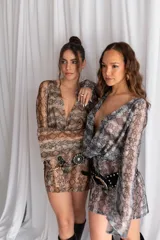 Vestido corto confeccionado en tul y lycra con estampado animal print de serpiente, escote en V pronunciado y mangas largas con diseño acampanado.