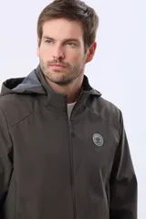 Campera repelente al agua y cortaviento de color negro, con capucha desmontable, cierre frontal y parche circular en el pecho.