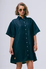 Vestido corto de denim azul oscuro, con cuello camisero, mangas cortas, cierre frontal con botones, bolsillo aplicado en el pecho y calce holgado.