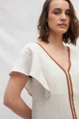 Vestido midi de lino en color azul, con escote en V tanto en el frente como en la espalda. Presenta mangas cortas con vuelo, silueta amplia y cintas verticales a contratono en el frente que estilizan la figura. Incluye bolsillos laterales.