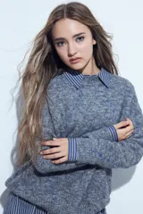 Sweater de tejido suave color marrón con diseño de líneas bordadas en color rojo. Presenta cuello redondo, manga larga y calce relajado.