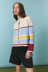 Cardigan de punto con diseño de rayas horizontales en tonos crema, celeste, amarillo y bordó. Presenta cuello redondo, cierre frontal con botones y mangas largas con puños en contraste.