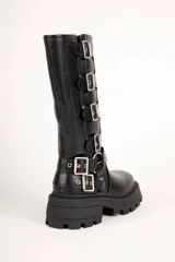 Bota alta tipo biker Daniel Cassin de color negro, con suela track gruesa y taco bajo. Presenta múltiples correas con hebillas metálicas plateadas en la caña y alrededor del tobillo.