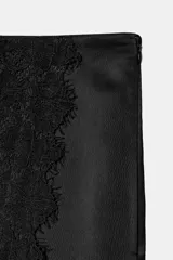 Falda pantalón negra de satén con detalles de encaje vertical y aberturas frontales. Cuenta con cierre lateral oculto.