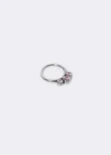 Aro de piercing plateado con tres pequeñas piedras de zirconia color rosa. El aro es de titanio y tiene cierre clicker.