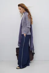 Pantalon de corte recto y pierna ancha, confeccionado en tela tipo denim color azul oscuro, con costuras a contratono y detalle de abertura lateral en el ruedo.