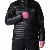 Campera acolchada de mujer Mountain Hardwear, color negro, con cierre frontal, cuello alto, bolsillo en el pecho y puños elásticos con detalle en color lila.