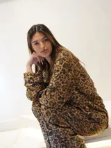 Conjunto de pijama con estampado animal print, compuesto por camisa de manga larga con botones y pantalón largo.