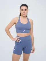 Top deportivo color gris azulado con diseño de espalda natación y el escudo del Club Nacional de Football en el centro.