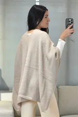 Capa tejida en color gris oscuro con textura de punto tipo waffle, diseño envolvente con cierre frontal anudado.