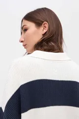 Buzo de punto con diseño de rayas horizontales en tonos bordó, azul marino y mostaza. Presenta cuello tipo polo con cartera de botones, mangas largas y calce holgado.