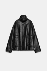 Chaqueta de corte oversize con acabado efecto piel. Presenta cuello alto, cierre frontal con cremallera y botones ocultos bajo solapa, bolsillos de plastrón con solapa en el delantero, mangas largas ajustables con trabillas y bajo ajustable con hebillas metálicas.