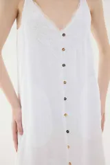 Vestido midi lencero marrón de lino, con escote en V pronunciado con aplique de encaje en contraste, breteles regulables y botonadura frontal decorativa.
