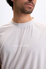 Remera oversize color gris claro con estampado trasero en color azul que dice "Pure and Just Balanced" y una frase motivacional debajo.