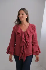 Blusa de lino color bordó con escote en V, volados frontales y mangas largas con doble volado en los puños.