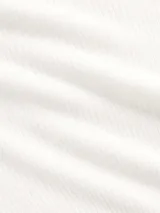 Buzo de tejido fino y semitransparente con cuello redondo y mangas largas, diseñado con una capa superpuesta estilo musculosa de punto acanalado.