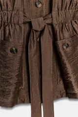 Blazer marrón de cuello redondo, manga larga y cierre frontal con botones. Cuenta con bolsillos de plastrón en el delantero y cintura ajustable con cinturón del mismo tejido.