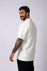 Chomba de manga corta con cuello polo, confeccionada en tejido de punto acanalado de textura pesada. Presenta un calce relajado y cuenta con una pequeña etiqueta distintiva en el ruedo.