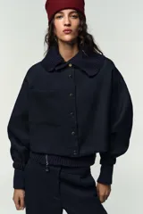 Pantalón de tiro alto con pernera recta, bolsillos delanteros y bolsillos de plastrón en la espalda. Presenta detalle de costura marcada en el frente y cierre con cremallera, botón interior y gancho.