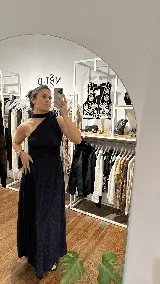 Vestido largo de fiesta color azul oscuro con acabado brillante, diseño de un solo hombro con detalle de cuello tipo choker y falda amplia con caída fluida.