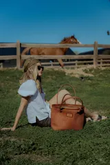 Cartera tipo canasto color marrón, hecha en 100% cuero con diseño tejido. Tiene bolsillo interno, porta llaves y cierre.