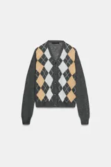 Chaqueta de punto con cuello en pico y manga larga. Presenta un diseño de estampado de rombos en tonos gris, beige y blanco en la parte frontal y cierre frontal con botones.