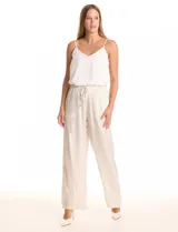 Pantalón wide leg de tela laminada metalizada color blanco, con pretina elástica y lazo de ajuste en la cintura. Cuenta con bolsillos laterales.