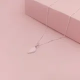 Dije de plata 925 con diseño de corazón dividido en dos mitades, cada una con su propia argolla de sujeción.