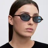 Lentes de sol con montura ovalada de color mostaza y cristales celestes polarizados.