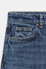Jeans de mezclilla en color negro gastado, tiro bajo, corte de pernera recta y diseño clásico de cinco bolsillos con cierre frontal de cremallera y botón metálico.