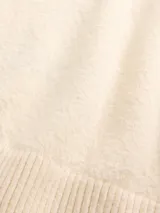 Buzo de punto con cuello redondo, manga larga y puños acanalados, confeccionado en tejido suave de textura fina.