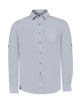 Camisa de manga larga RKF modelo Galiton, confeccionada en popelina de algodón orgánico color gris claro. Presenta cuello camisero, cierre frontal con botones de madera, bolsillo en el pecho y mangas con opción de arremangado mediante trabilla y botón.