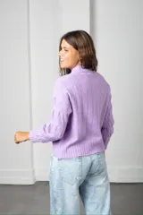 Buzo de tejido de punto con diseño de ochos, cuello redondo y mangas largas con puños acanalados.