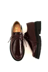 Zapatos tipo wallabee de cuero metalizado en tono peltre, con cordones negros y suela track de goma negra con plataforma.