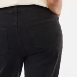Jean de corte bootcut color negro, con cintura alta y ruedo deshilachado.