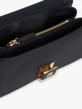 Cartera bandolera Tommy Hilfiger de diseño estructurado, confeccionada en jacquard con monogramas TH en tonos azul marino y beige, combinada con detalles en cuero sintético negro. Cuenta con solapa frontal, cierre metálico con logo, asa superior y correa extraíble.
