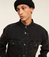 Camisa masculina de denim de algodón con efecto marmolado, corte oversized tipo boxy, cuello camisero, mangas largas, cierre frontal con botones y dos bolsillos frontales con solapa en el pecho.