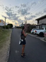 Cartera de mano con forma de hoja, confeccionada en cuero trenzado color naranja y negro. Asa corta trenzada de cuero negro.