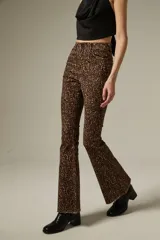 Pantalon de jean con corte flare y tiro alto, estampado con diseño animal print de leopardo en tonos marrones. Cuenta con bolsillos funcionales y ruedo desflecado.