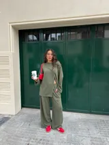 Conjunto gris melange confeccionado en lanilla, compuesto por una remera de manga larga con diseño cruzado en el frente y un pantalón largo de corte ancho con bolsillos.