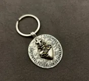 Set de tres llaveros de metal plateado con motivos religiosos, incluyendo un dije circular con la imagen del Sagrado Corazón de Jesús, un dije circular pequeño con una cruz y un dije con forma de cruz griega.