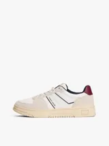 Zapatillas de corte bajo Tommy Jeans, confeccionadas en una combinación de cuero y ante en tonos blanco, beige y burdeos. Presentan suela cupsole de goma en color crema, cordones moteados y el logo de la marca en el lateral.