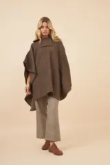 Poncho unisex de lana color marrón con cuello alto y broche a presión. Diseño exclusivo de Don Baez, hecho en Uruguay.